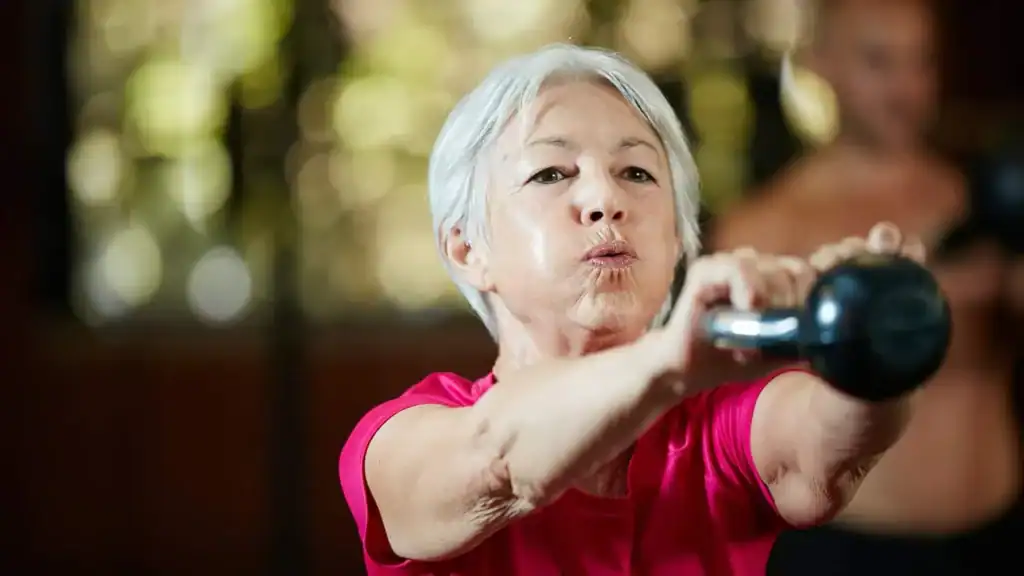 Older woman doing weight training Hampton to help her strength and longevity 