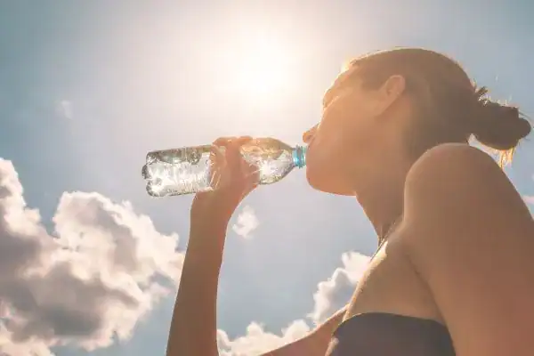 Hydration: The Secret Ingredient for a Toned Stomach and Enhanced Fitness 3 Image of woman drinking water to hydrate Hampton after run.
