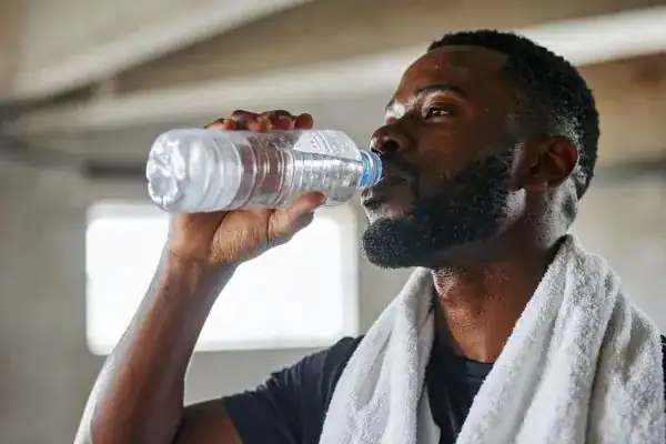 Hydration: The Secret Ingredient for a Toned Stomach and Enhanced Fitness 1 Image of man drinking water to improve hydration Hampton after work out.